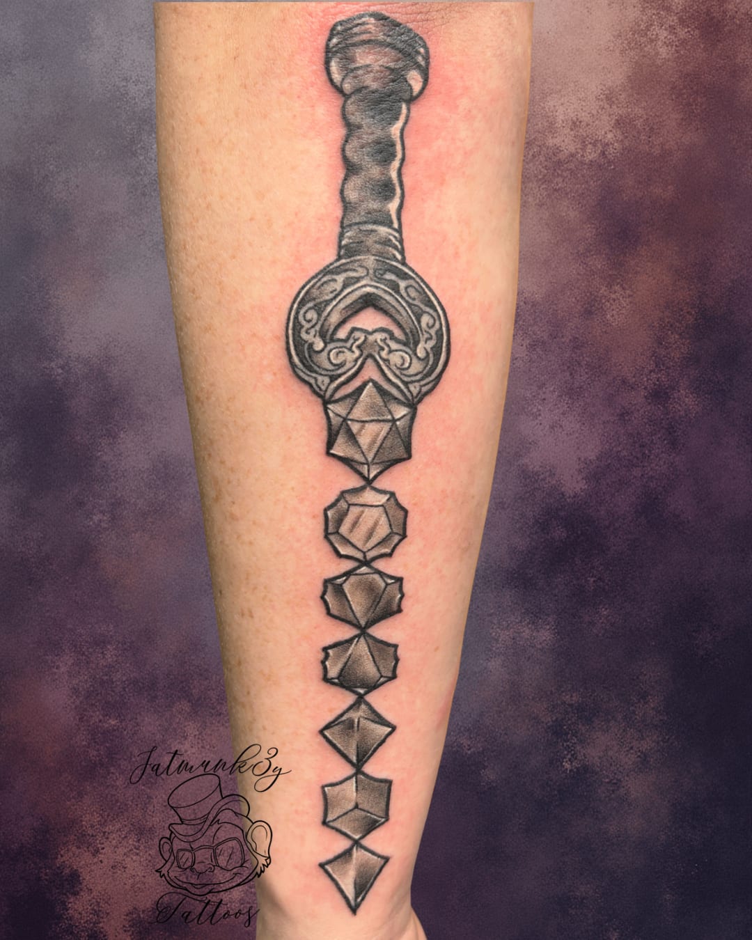 Custom black and grey fantasy sword and DnD dice tattoo on arm by Spencer Holmes, Fatmunk3y Tattoos Columbus Ohio